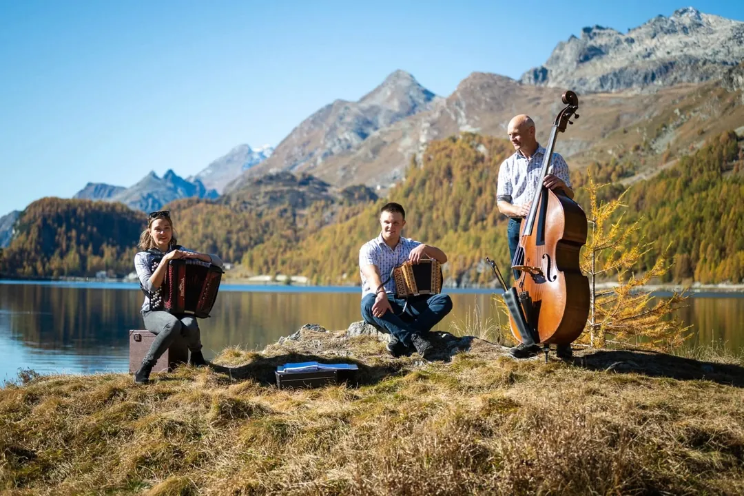 Musicisti con organetti svizzeri e contrabbasso sulla riva del lago di Sils