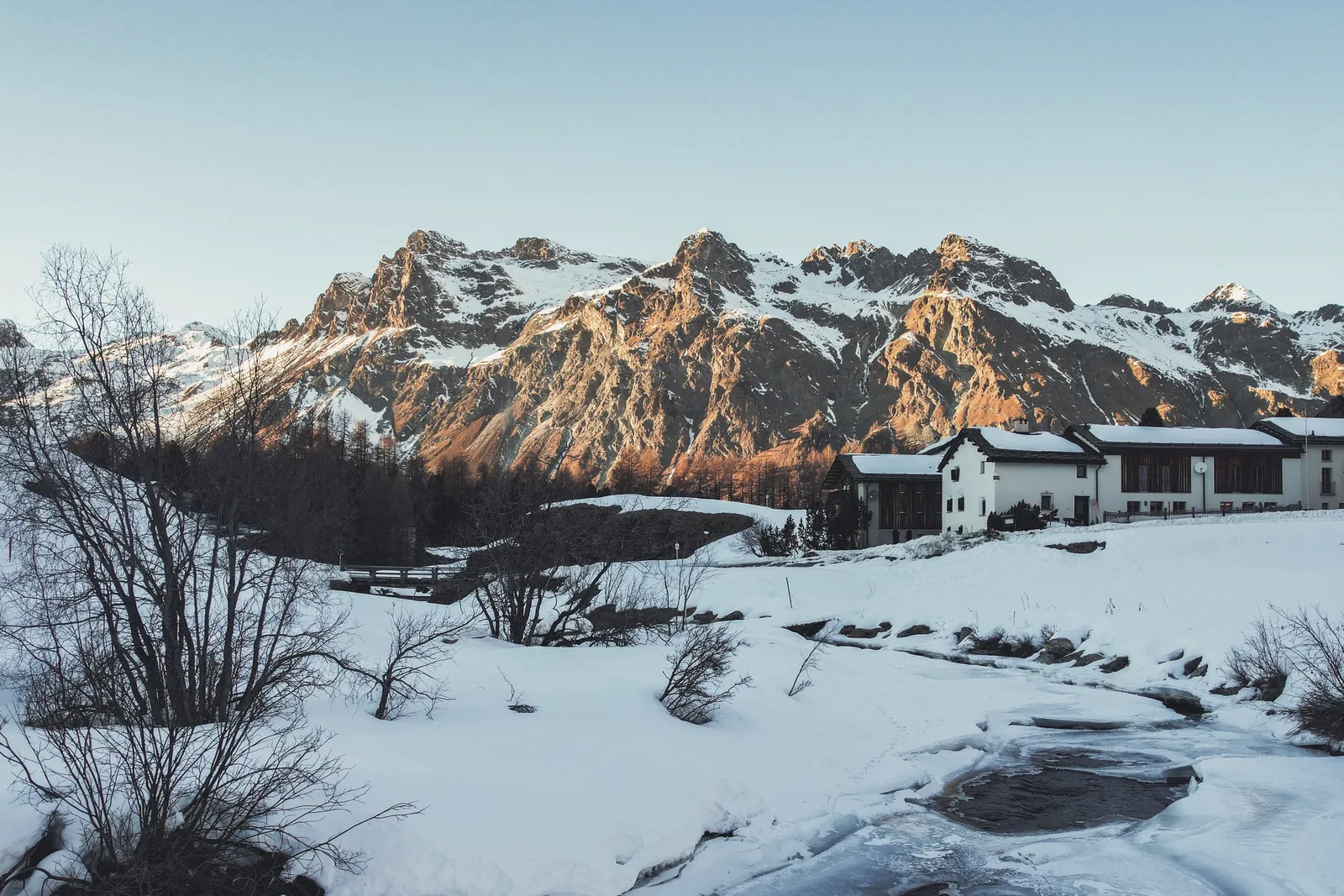 Enrosadira sulle montagne, la Chesa Pool nella neve