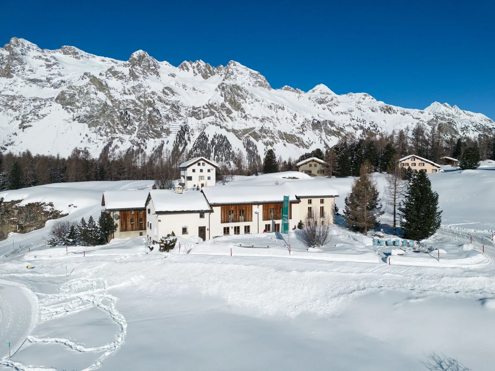 Die Chesa Pool im Schnee, dahinter die Bergkette