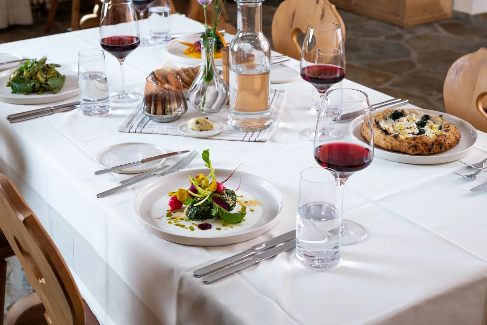 A laid table in the evening with a vegetarian dish and red wine