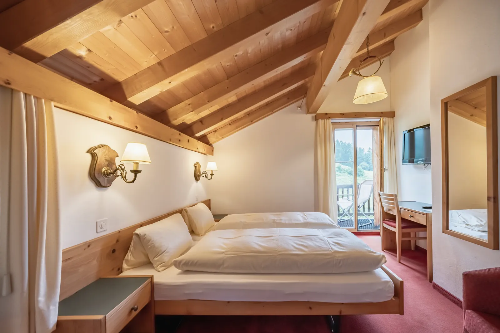 Zimmer unter dem Dach mit Holzbalken und Balkon