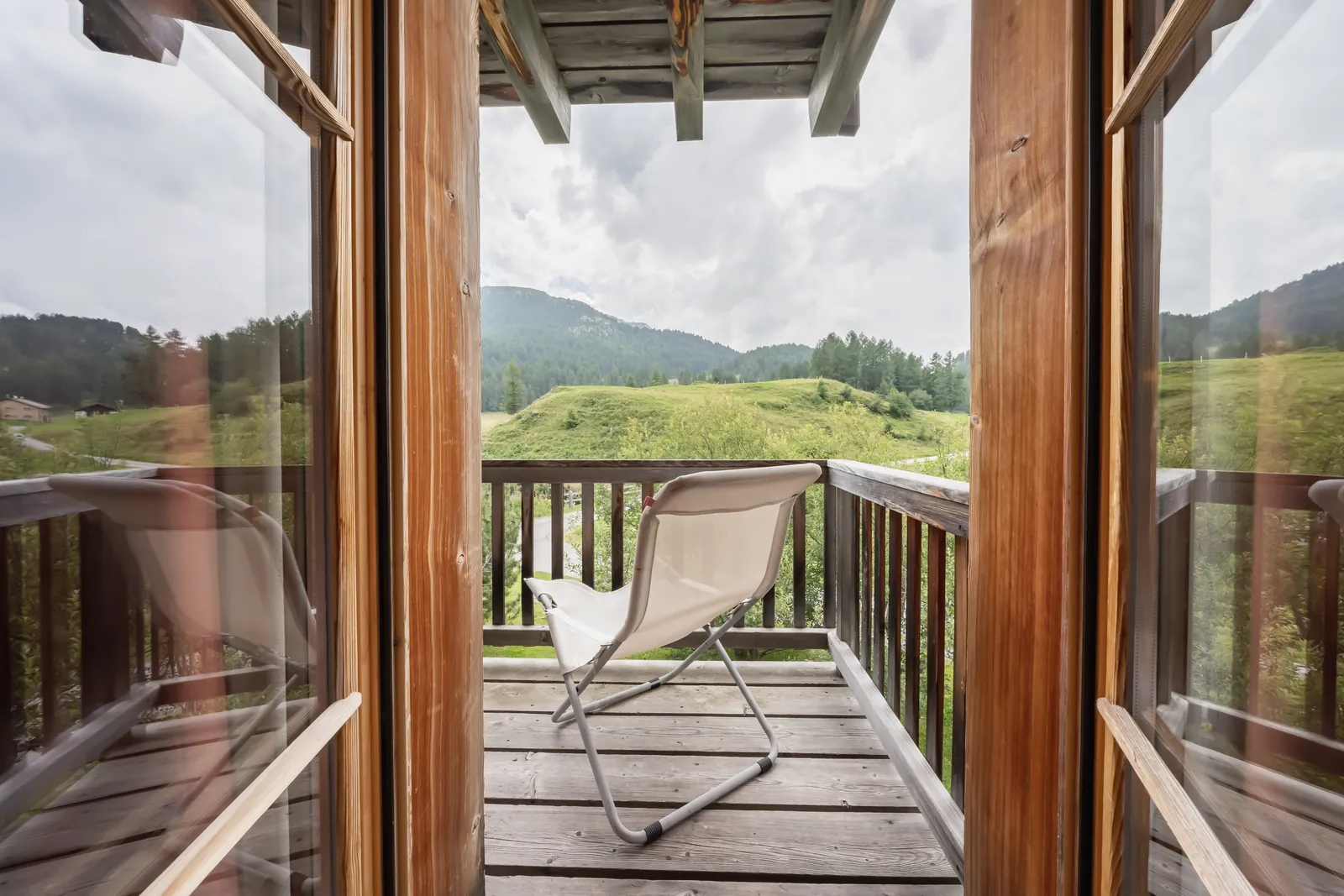 Balkon mit Liegestuhl und Blick ins Tal