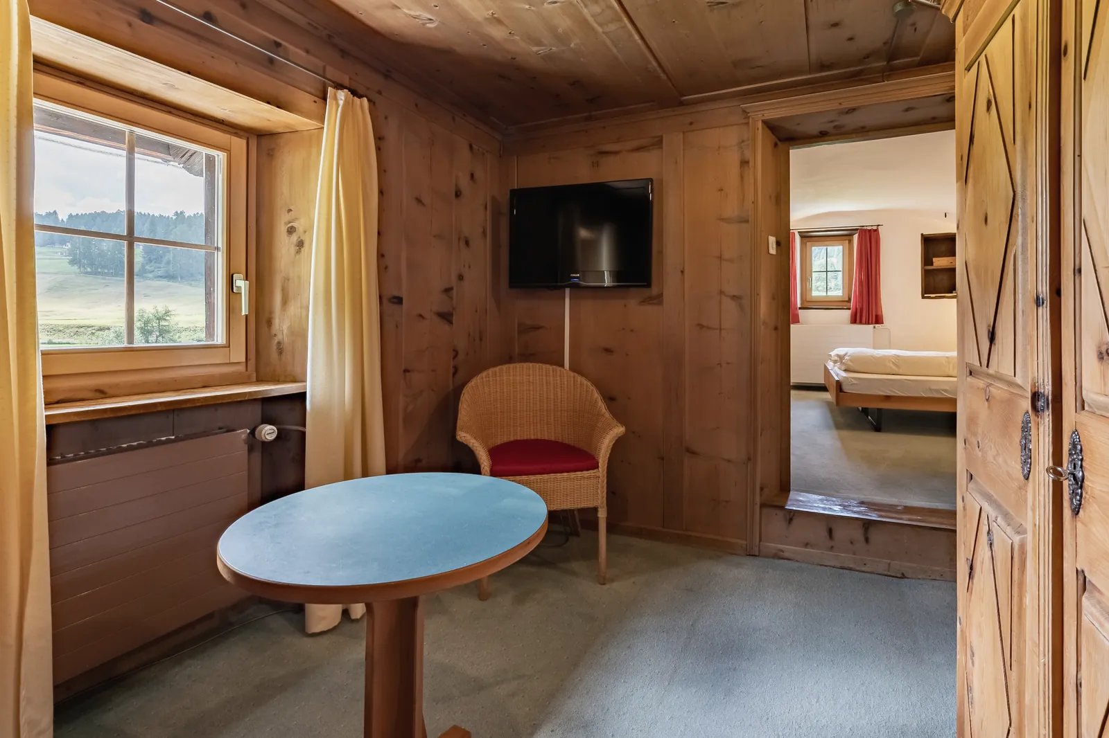 Stübli aus Arvenholz mit Durchblick ins Schlafzimmer